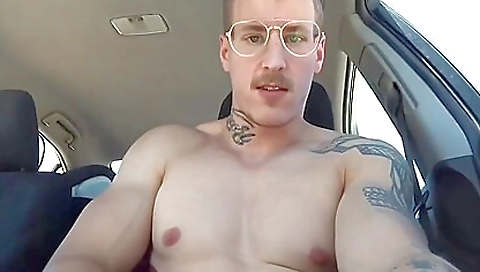 Car driver in his tattooed shorts shows his hot body